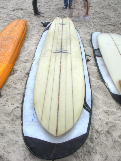 four surfboards are shown sitting on the sand