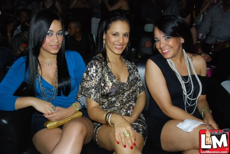 three ladies in dresses are smiling at the camera