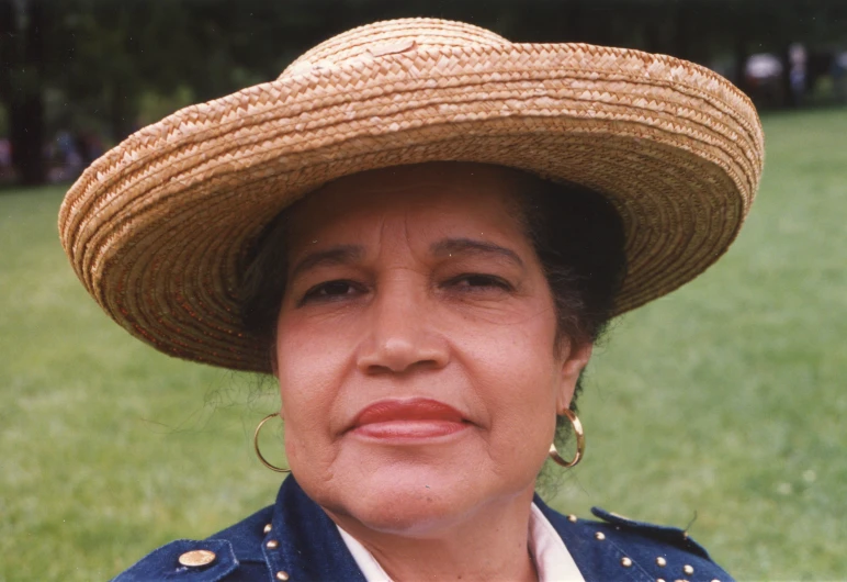 woman with brown earrings wearing large straw hat