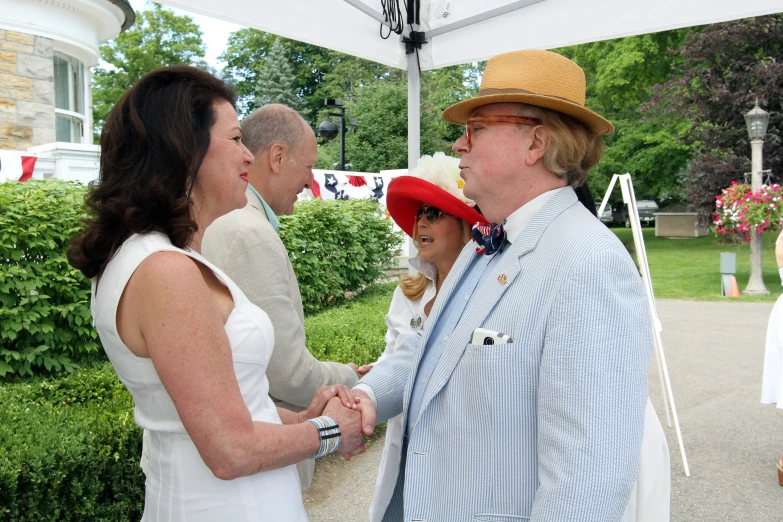 two women and one man standing in front of a tent