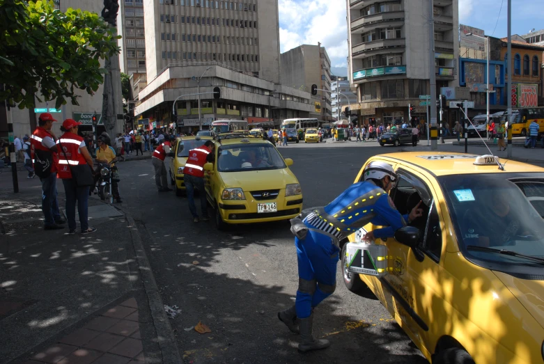 two men with masks are putting the driver in a taxi