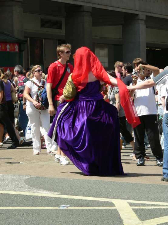 a woman wearing a purple dress with a large purple scarf around her waist