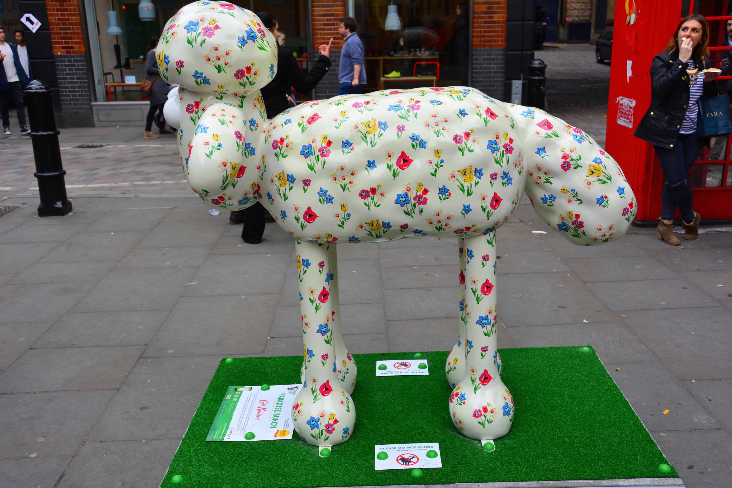 a large white balloon shaped dog stands on a green carpet