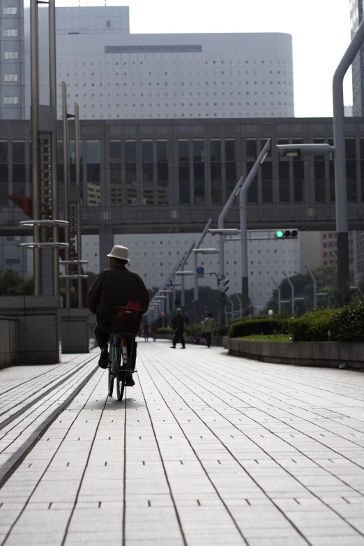 a man on a bicycle is riding down the sidewalk