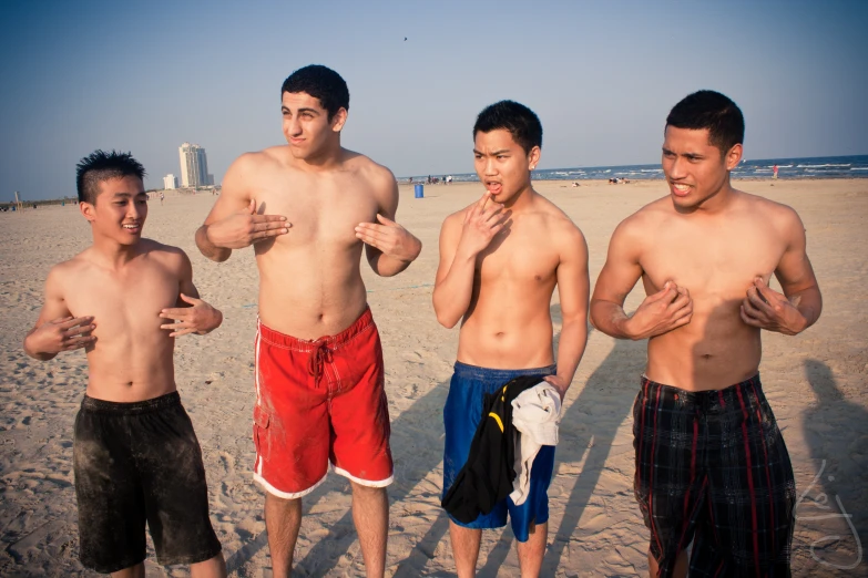 three men posing for a picture at the beach