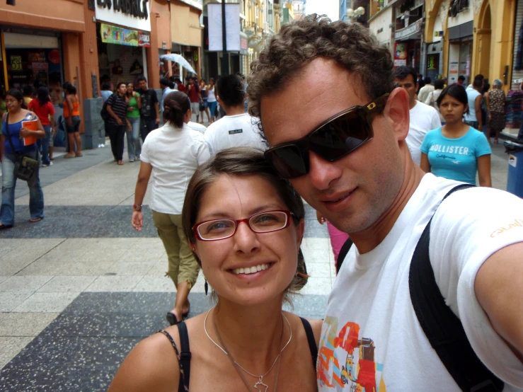 the man poses for the camera with his lady in front of a crowd