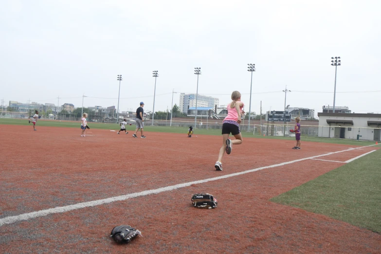 people are in a baseball field on red dirt