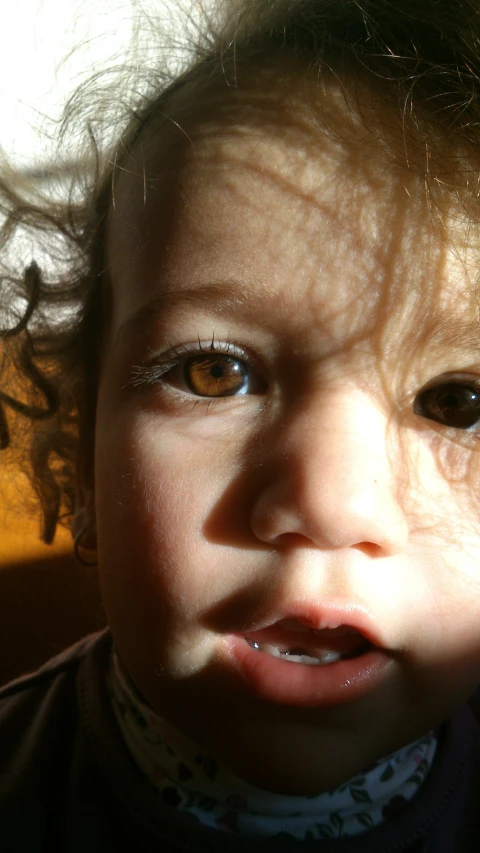 a close up of a child with brown hair and a tie on