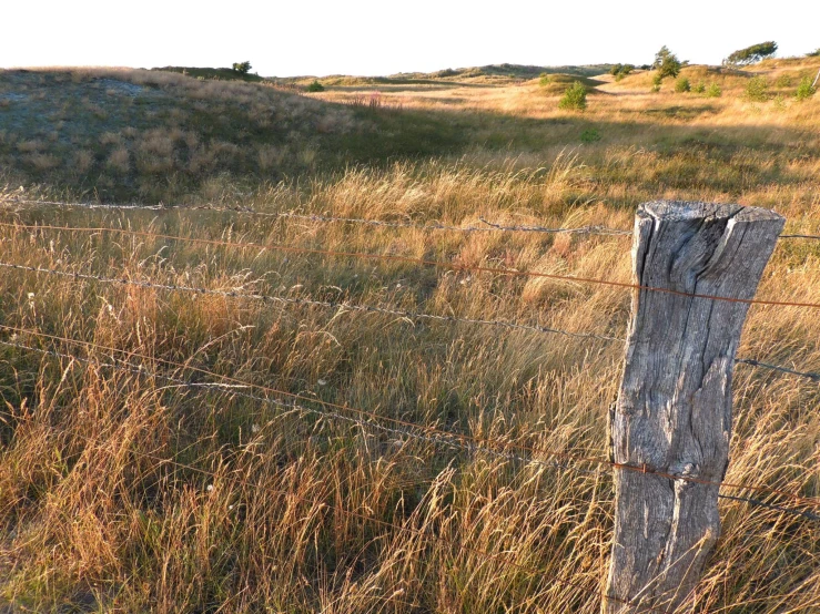 an old fence is in the middle of a field