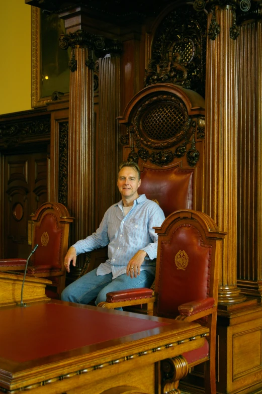 a man sits in the middle of a room of wooden paneled walls