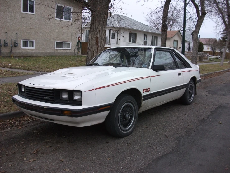 a white car that is on the side of a road