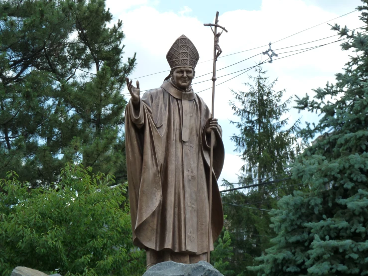 the statue of jesus outside of a small tree lined cemetery