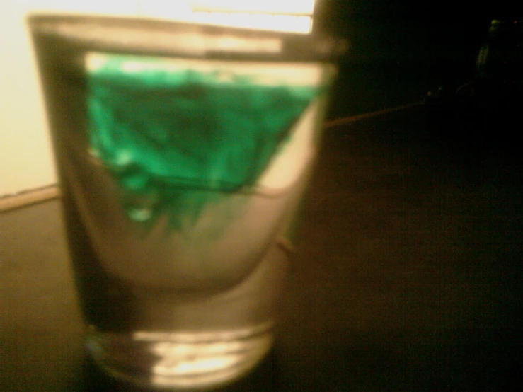 a green substance in a clear glass on a table