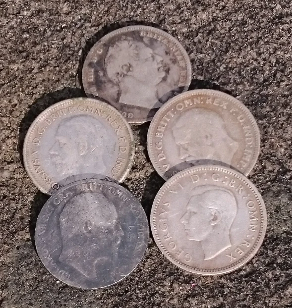 three old british coin next to an image of a lady's face