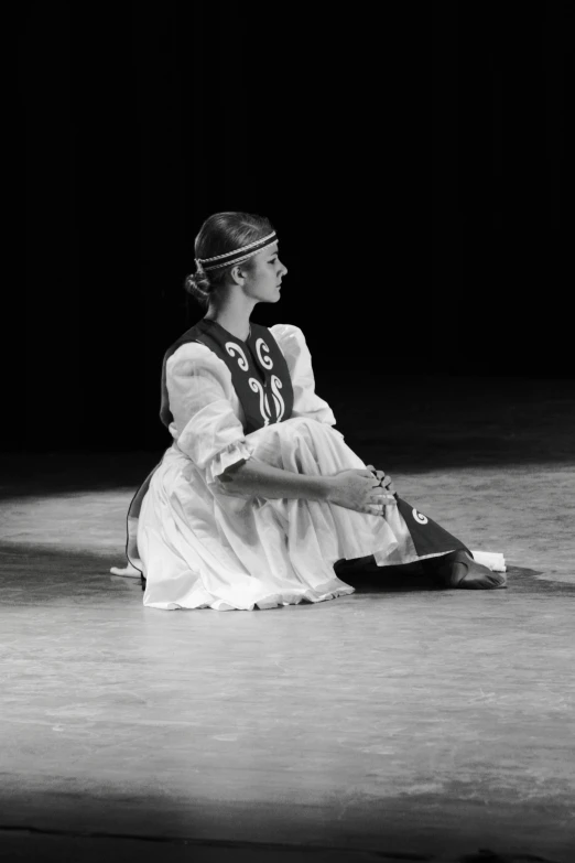 a woman in a dress is sitting and talking on a phone