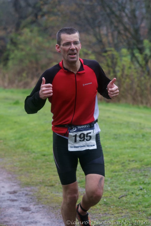 a man in cycling gear running down a path