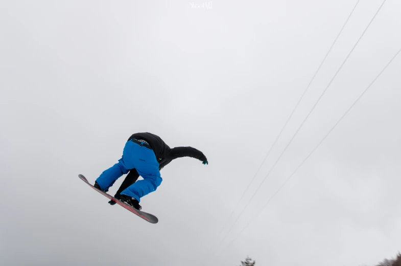 a snowboarder jumping through the air with one hand in the air