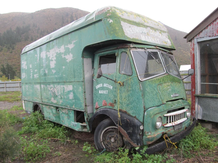 a green truck sitting in front of a building