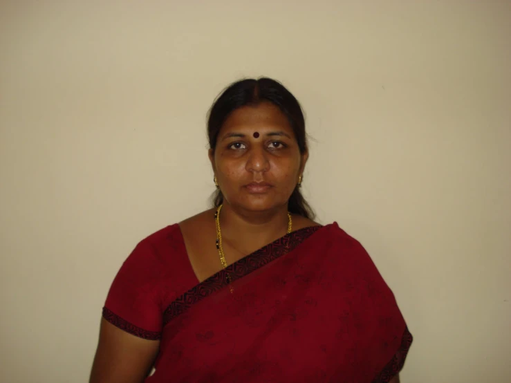 an indian woman with gold jewelry on her neck and red saree