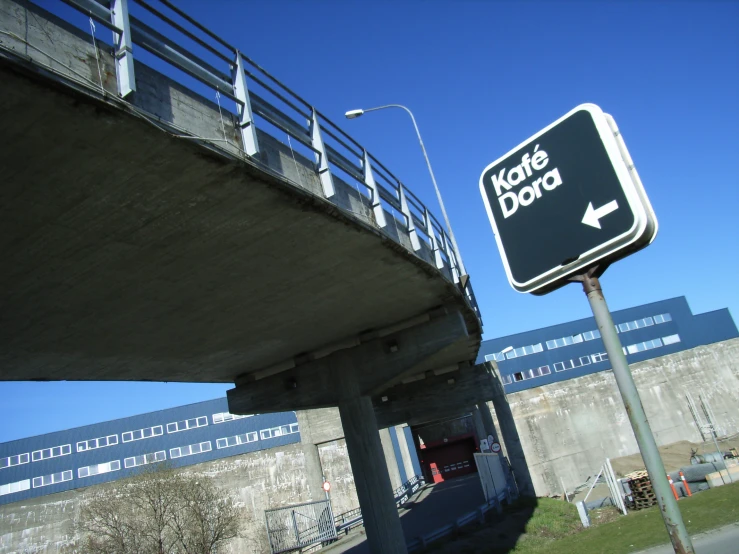 there is a sign with arrows under the bridge