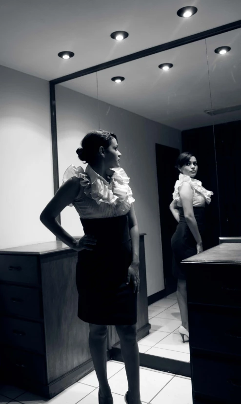 woman looking in a mirror and wearing an apron