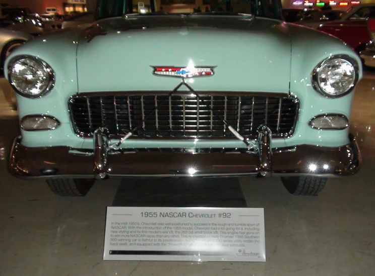 the front end of an antique car parked on display in a museum