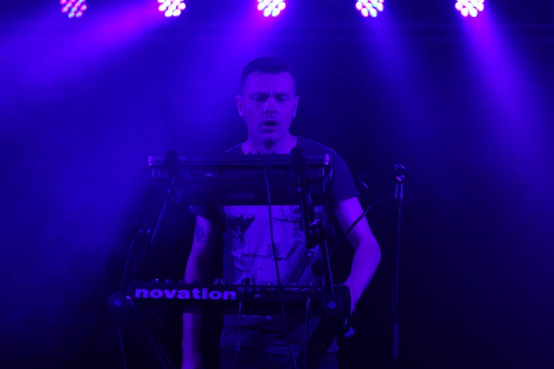 a man playing a keyboard on stage at night