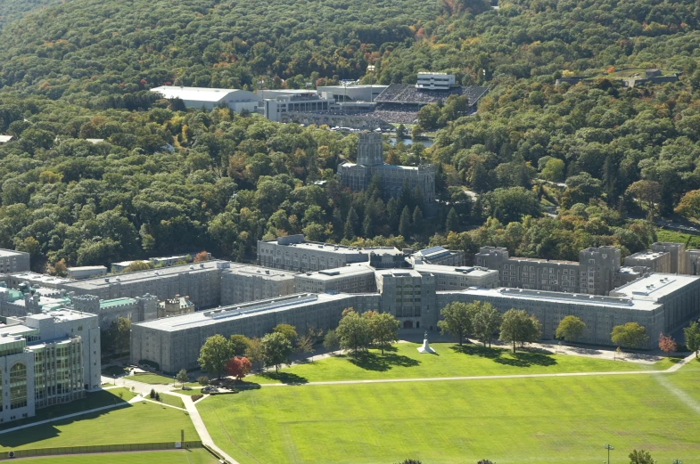 an aerial view of two buildings, a large grassy field and trees