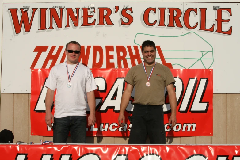 two men standing in front of the winners sign