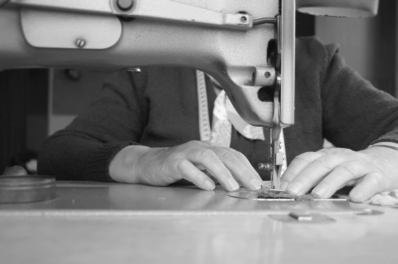 black and white po of hands on top of machine