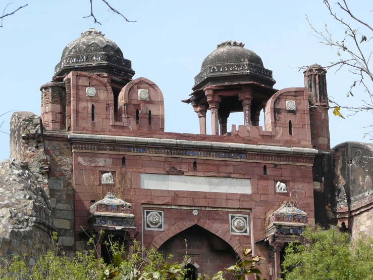 a large brick structure surrounded by trees with windows and arches