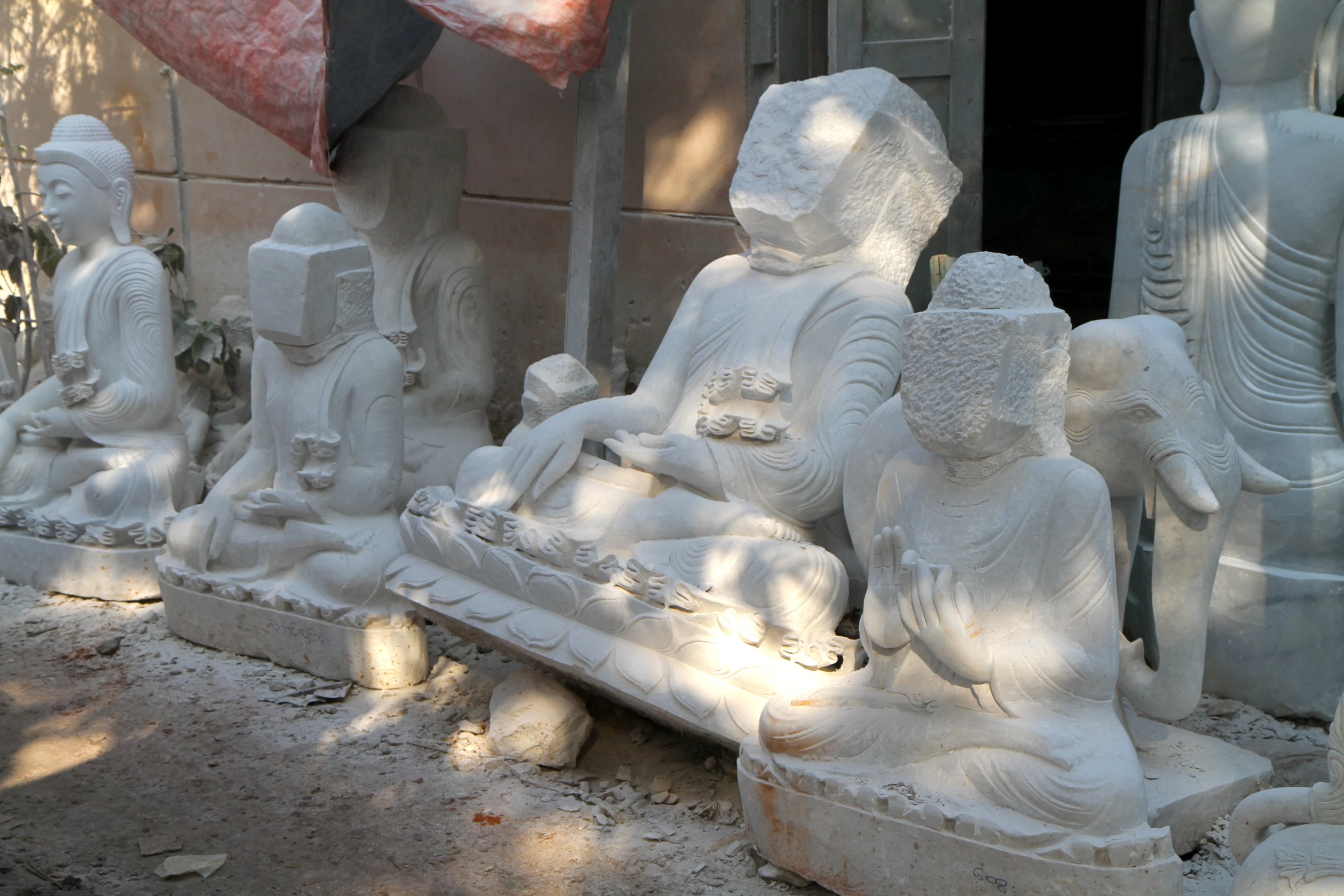 a row of buddha statues on the side of a building