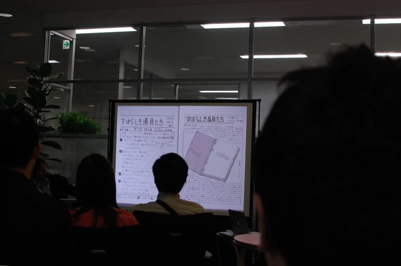 two people speaking at a lecture in an office