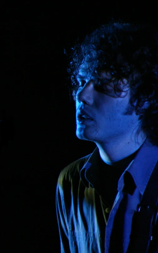 a man with curly hair wearing a shirt