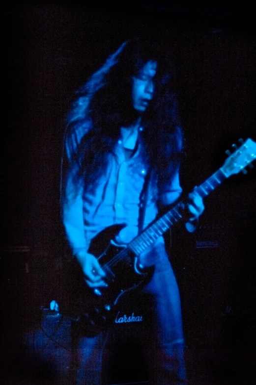 the young man is playing his guitar on stage