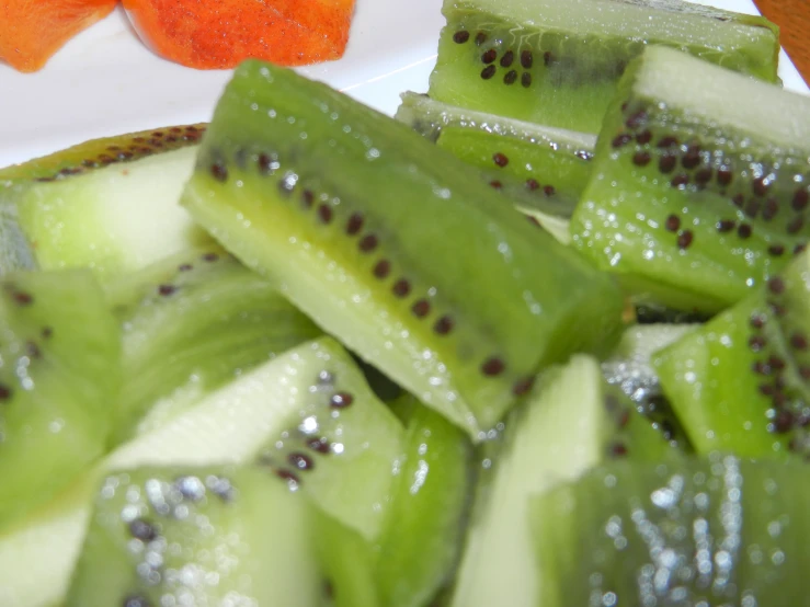 sliced cucumber slices in white dish with other fruit items