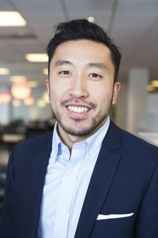 a man with a beard wearing a suit and smiling