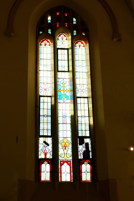 the stained glass windows of a church are shining in the light