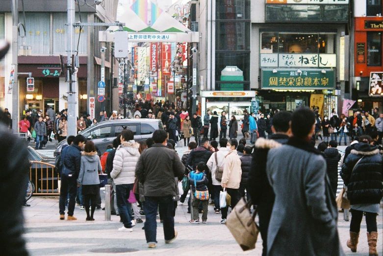 people crossing at a crowded downtown area, surrounded by skyscrs