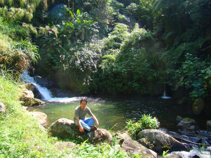 a person sitting on some rocks and water