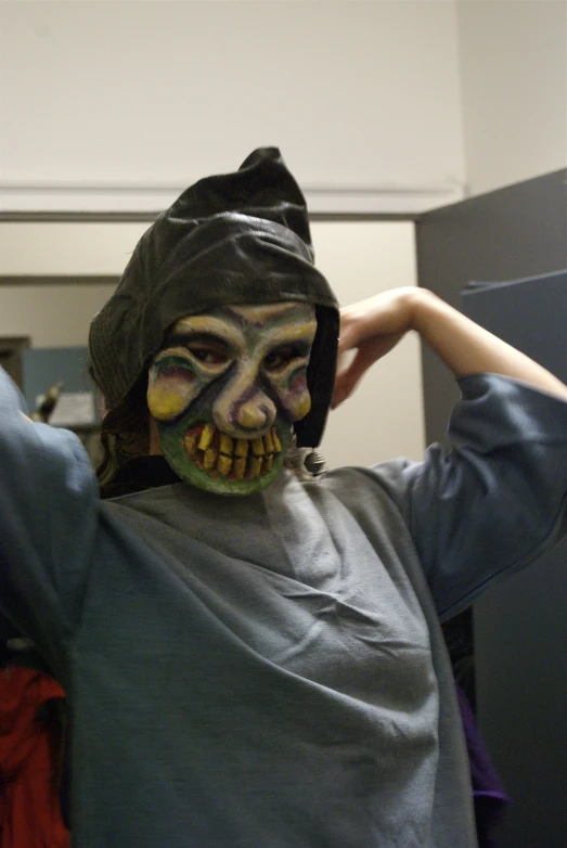 a boy is dressed up and wears a scary mask