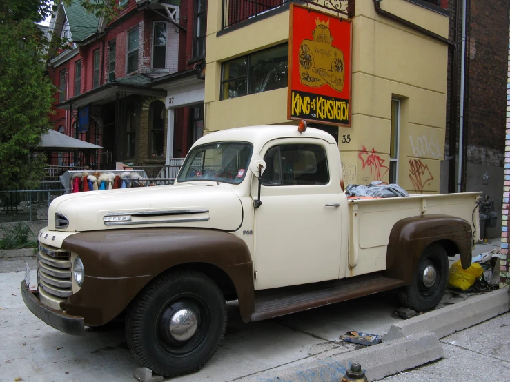 an old fashioned pickup truck parked in front of a building