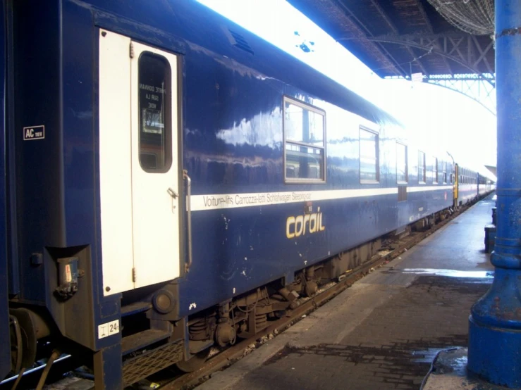 a train parked on the railroad platform with its doors open