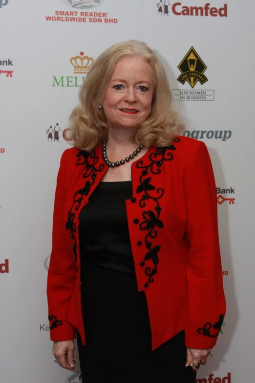 a woman standing on the red carpet wearing a black dress