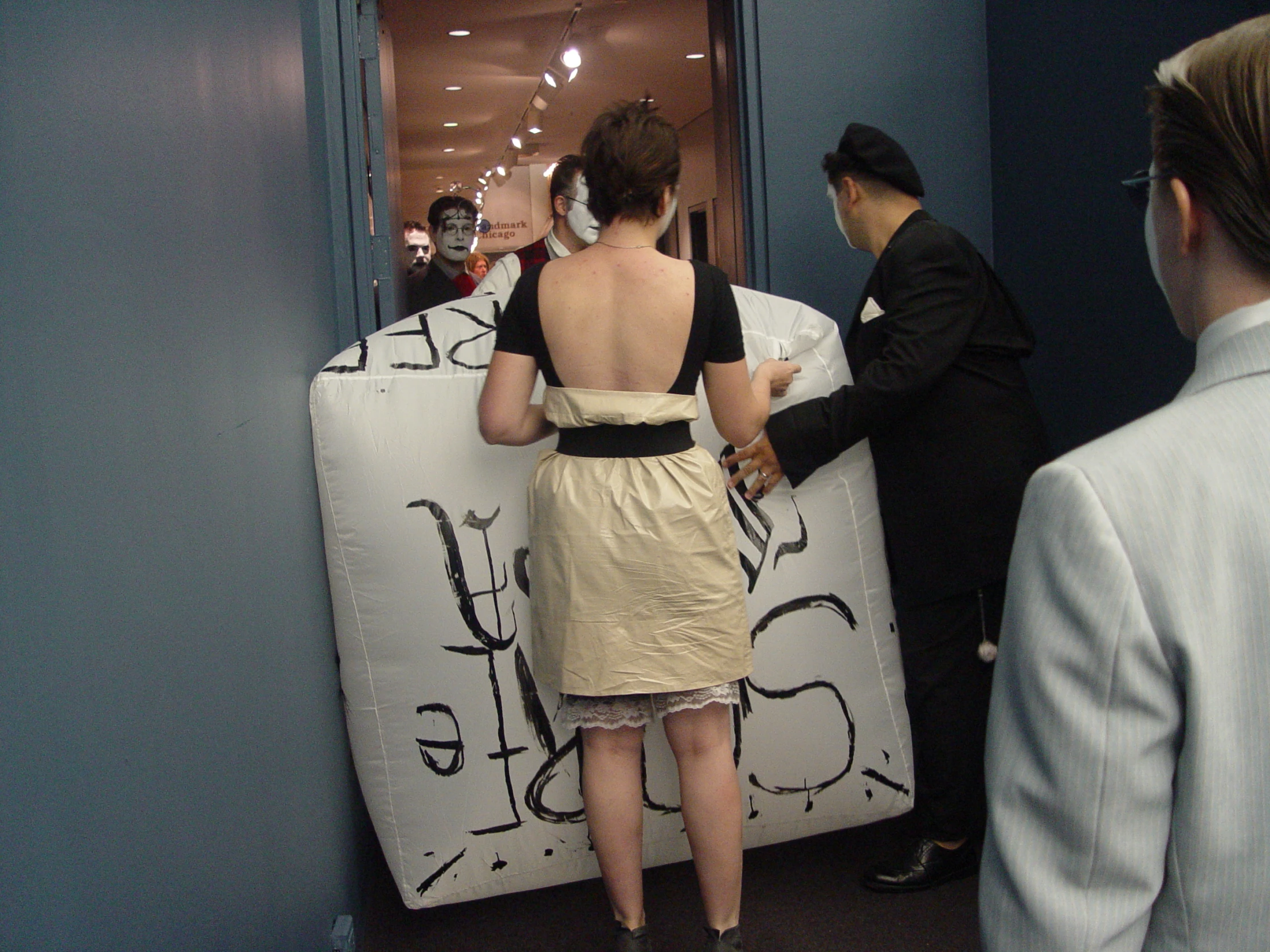 a woman standing next to a refrigerator covered in graffiti