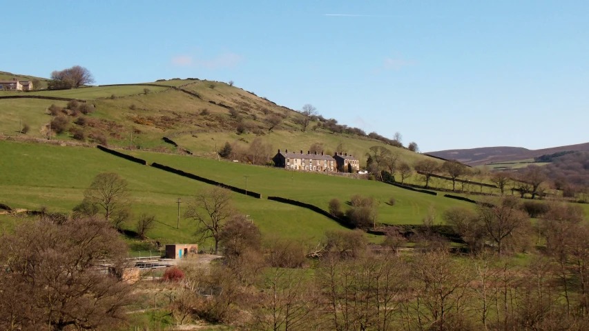 a large house sitting on top of a lush green hillside