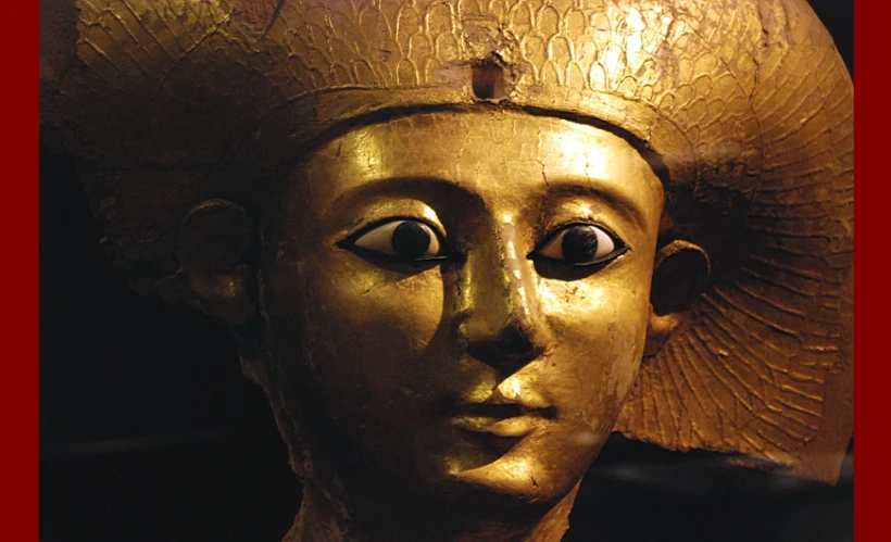 the golden head of a statue wearing a golden hat