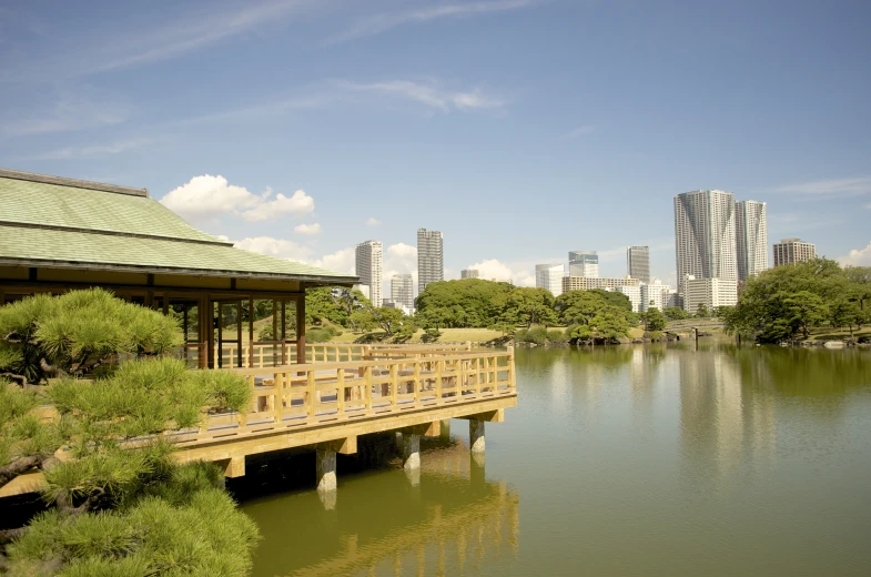 a yellow bridge sits over the water in a city park