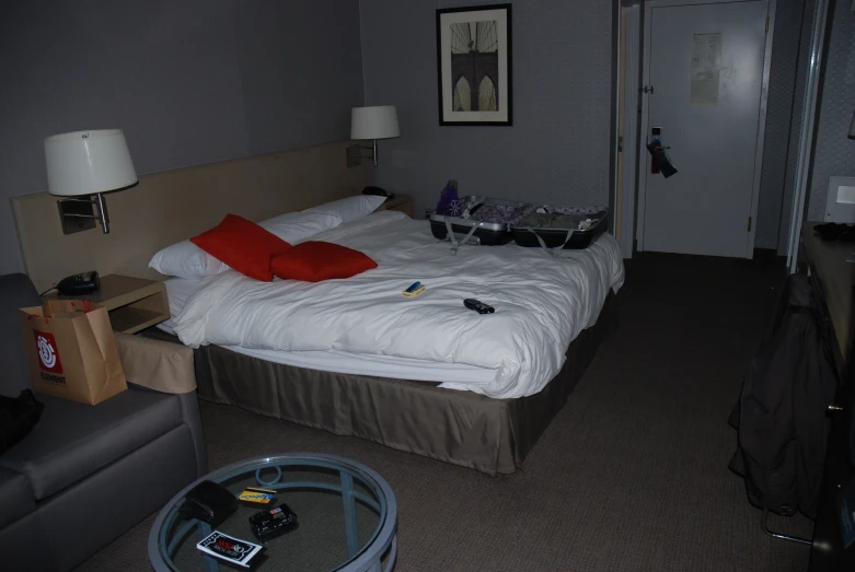 a bed with red pillows, a large white blanket and brown headboard