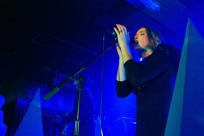 the young woman is singing into her microphone